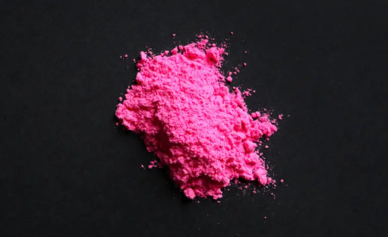 Montón de polvo rosa sobre fondo negro, la presentación habitual del tusi